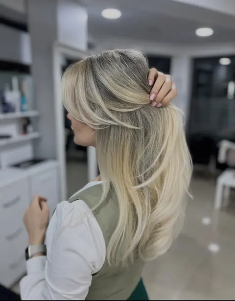 Păr blond lung, tuns în straturi, în salon