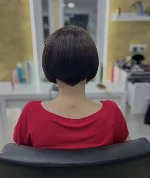 Tunsoare bob brunet, scurtă la ceafă, din spate, în salon