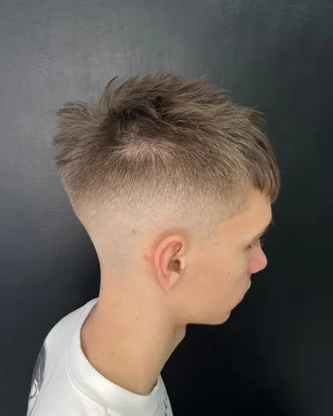 Tunsoare fade din profil, cu bretonul texturat, pe fundal negru