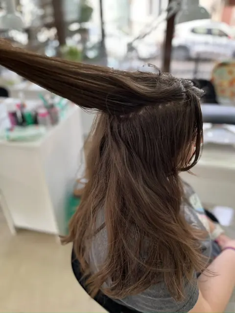 Păr șaten ridicat pe o secțiune, în timpul lucrului, în salon