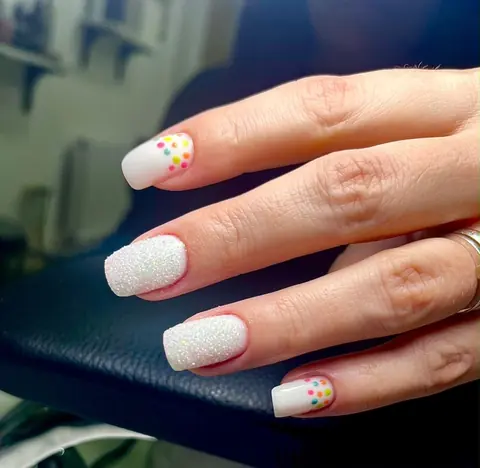 Unghii pătrate albe, două cu sclipici și două cu buline colorate